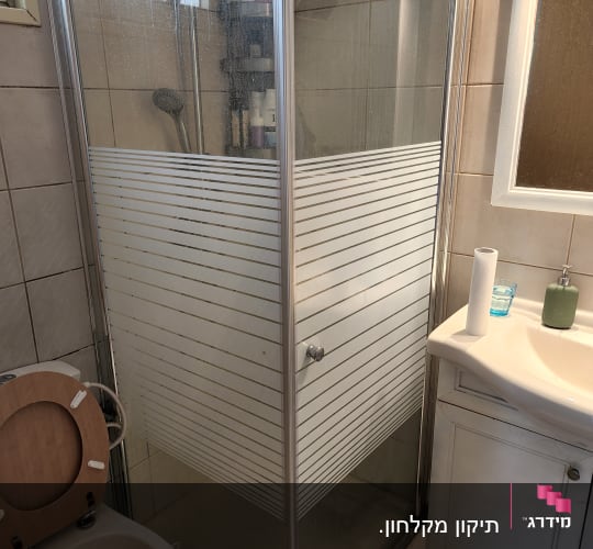 מקלחון זכוכית עם מדף מוצרים בפנים